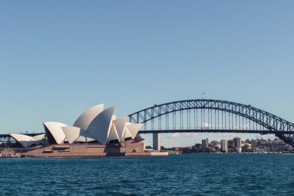 Vue emblématique de Sydney avec l’Opéra et le Harbour Bridge, une ville phare pour l’investissement immobilier international et la location haut de gamme
