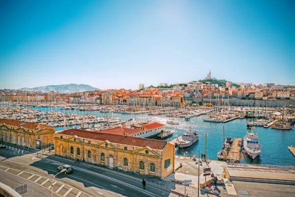 Le bassin rempli de voiliers et bateaux de plaisance et les façades colorées des immeubles qui bordent le port