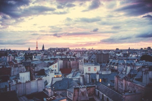 Paris au coucher du soleil, avec une vue sur les toits parisiens typiques.