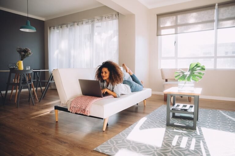 Jeune femme travaillant sur son ordinateur dans un appartement lumineux et moderne en location meublée
