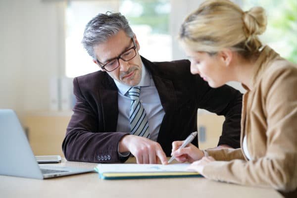 Un courtier immobilier qui est en train de signer avec son investisseur